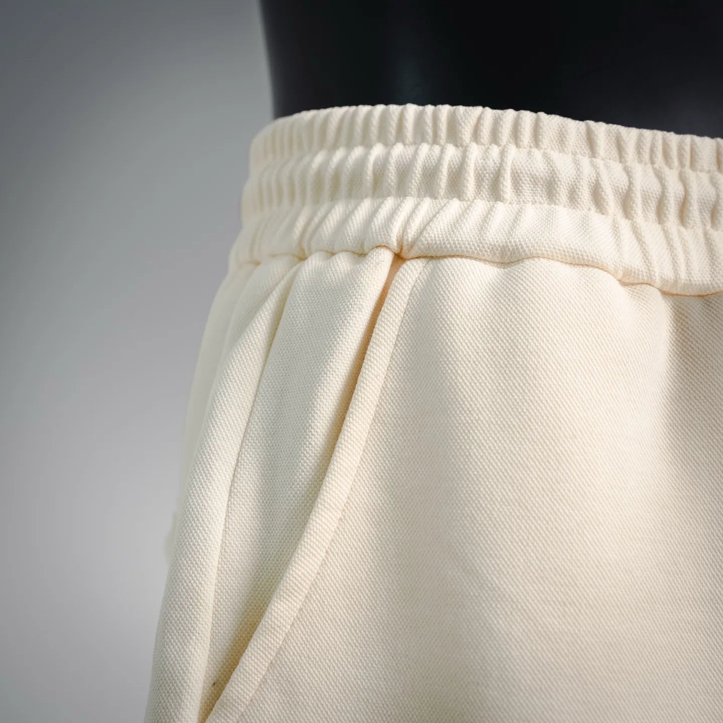 Cream shorts with drawstring tied at the waistband and elastic casing
