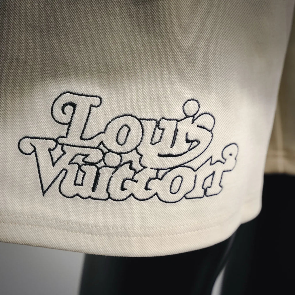 Cream shorts featuring a dark Louis Vuitton “World” style logo graphic on the leg