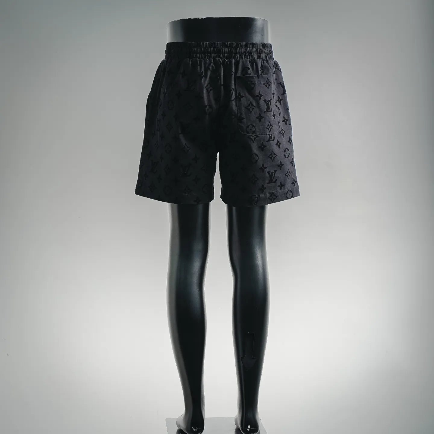 Black patterned shorts on mannequin legs, elastic waist and relaxed fit