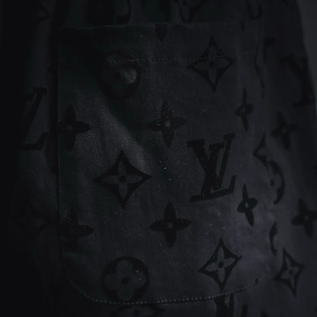 Close-up of black fabric with repeating star and monogram pattern