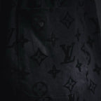 Close-up of black fabric with repeating star and monogram pattern