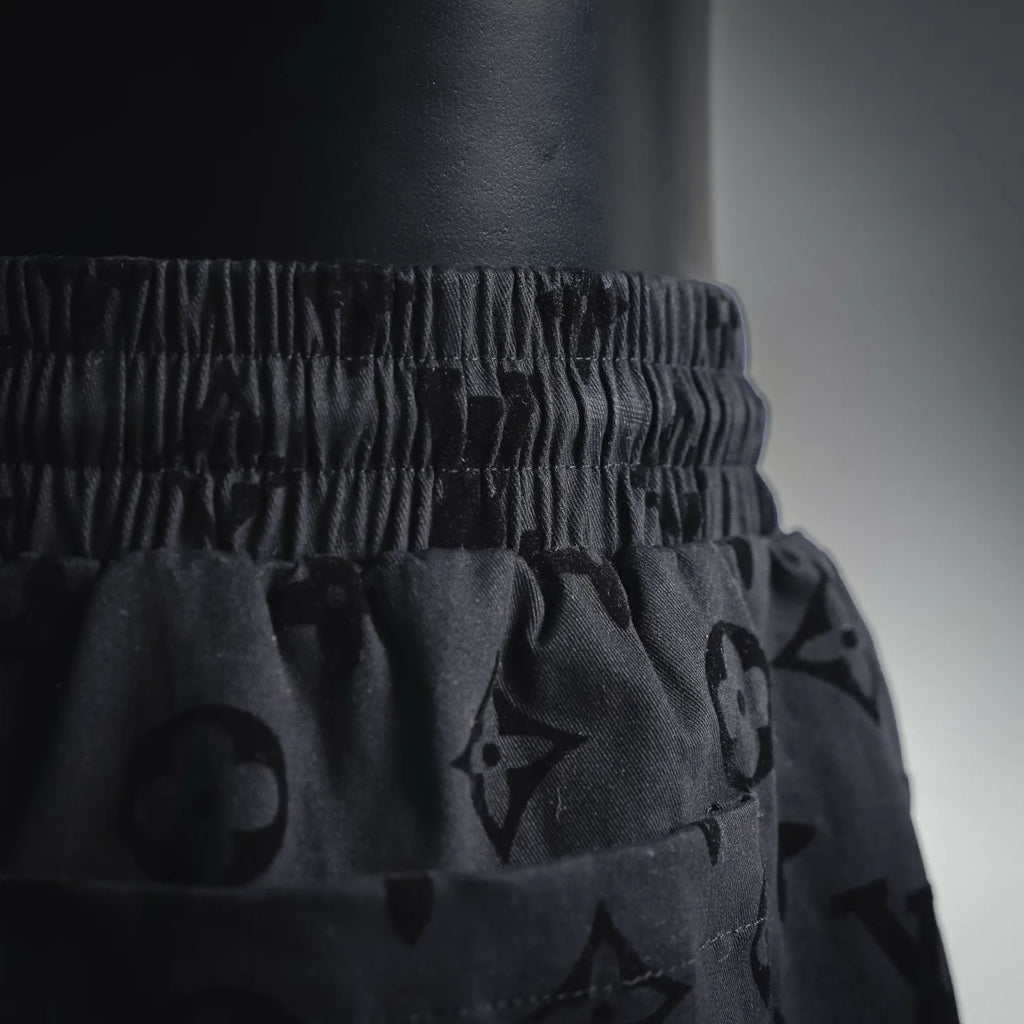 Elastic waistband and drawstring on black patterned shorts