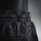 Elastic waistband and drawstring on black patterned shorts