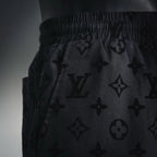 Close-up of black monogram shorts with gathered elastic waistband