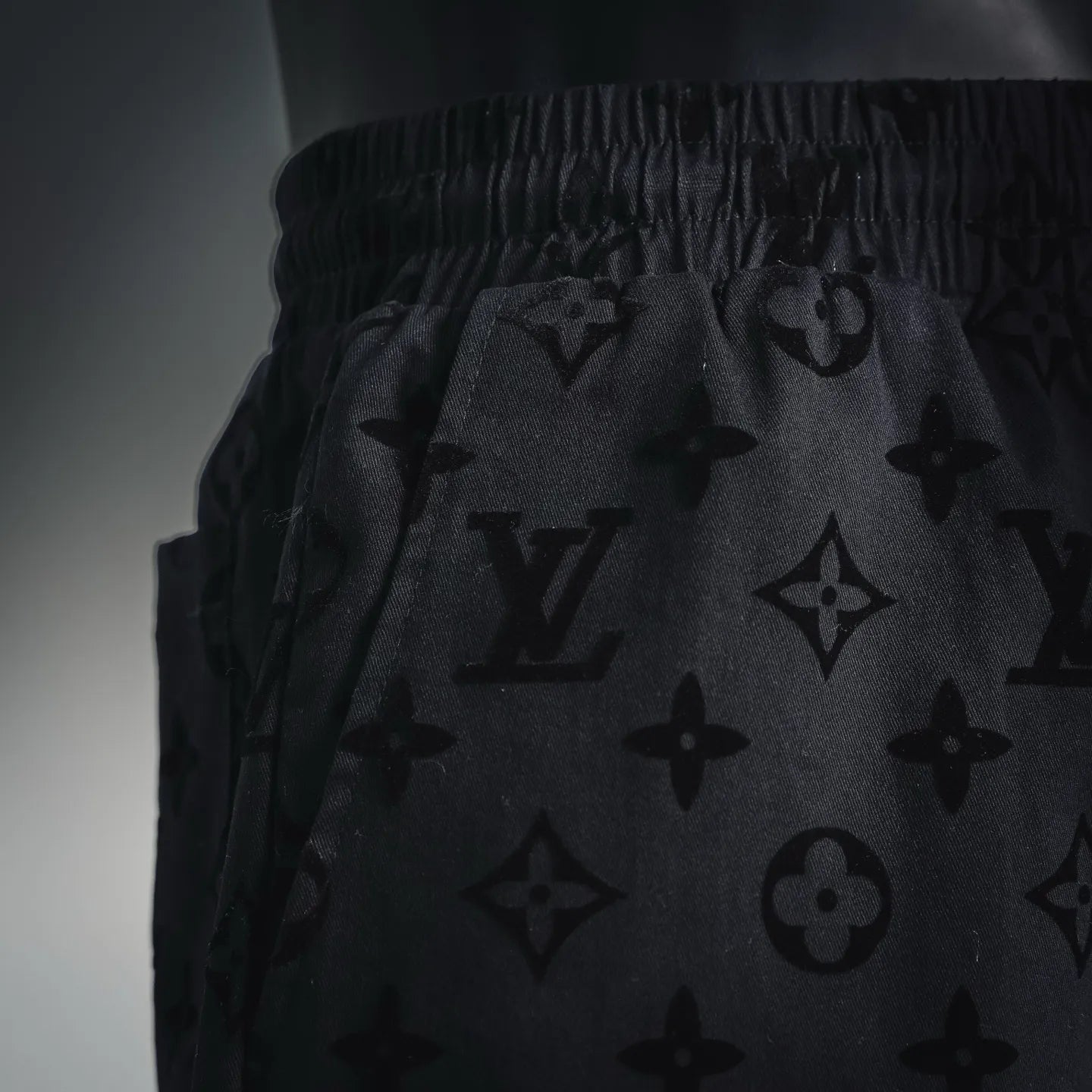 Close-up of black monogram shorts with gathered elastic waistband