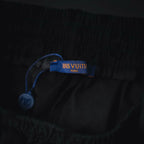 Black shorts fabric with blue brand label on waistband