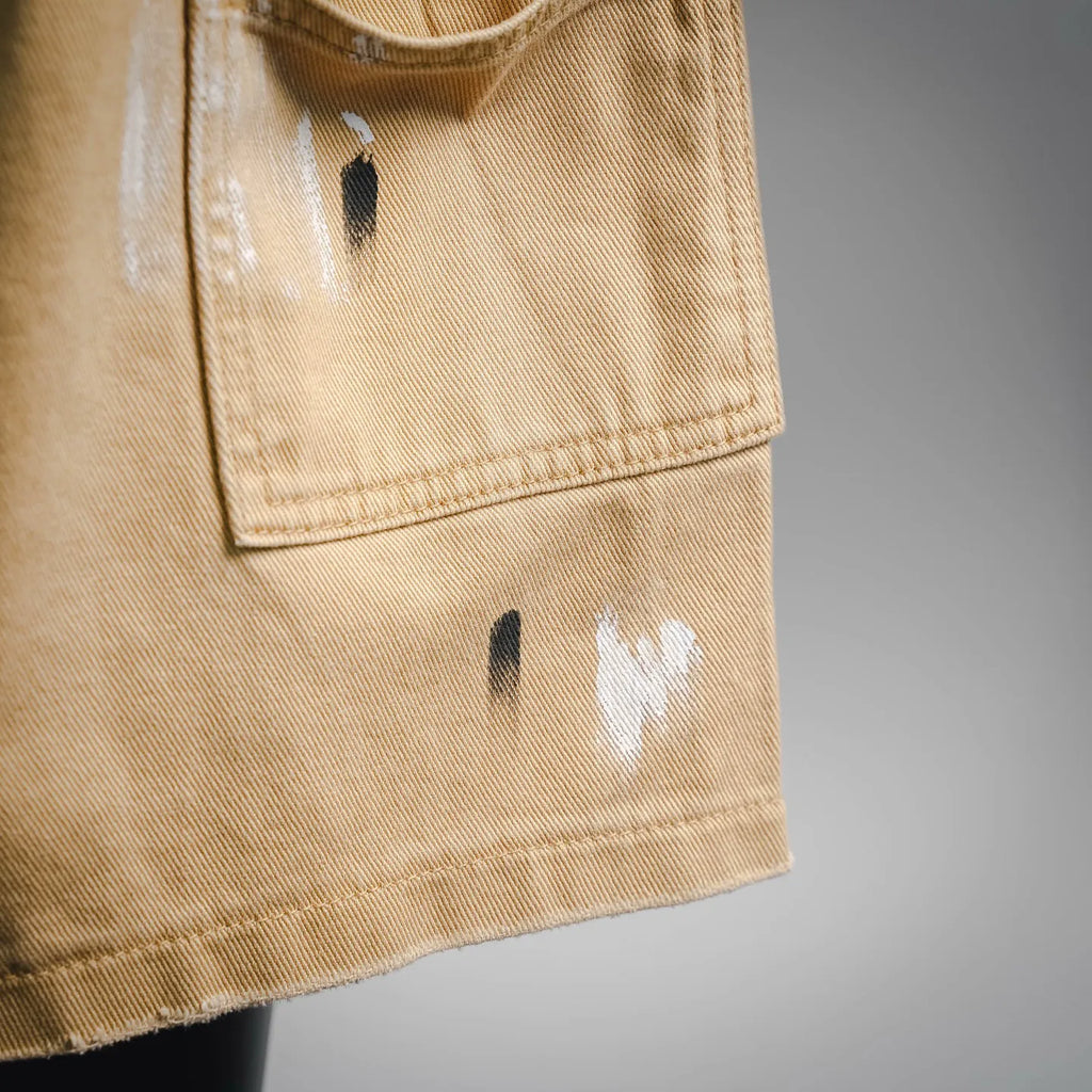 Beige LV shorts fabric close-up with distressed marks near the pocket