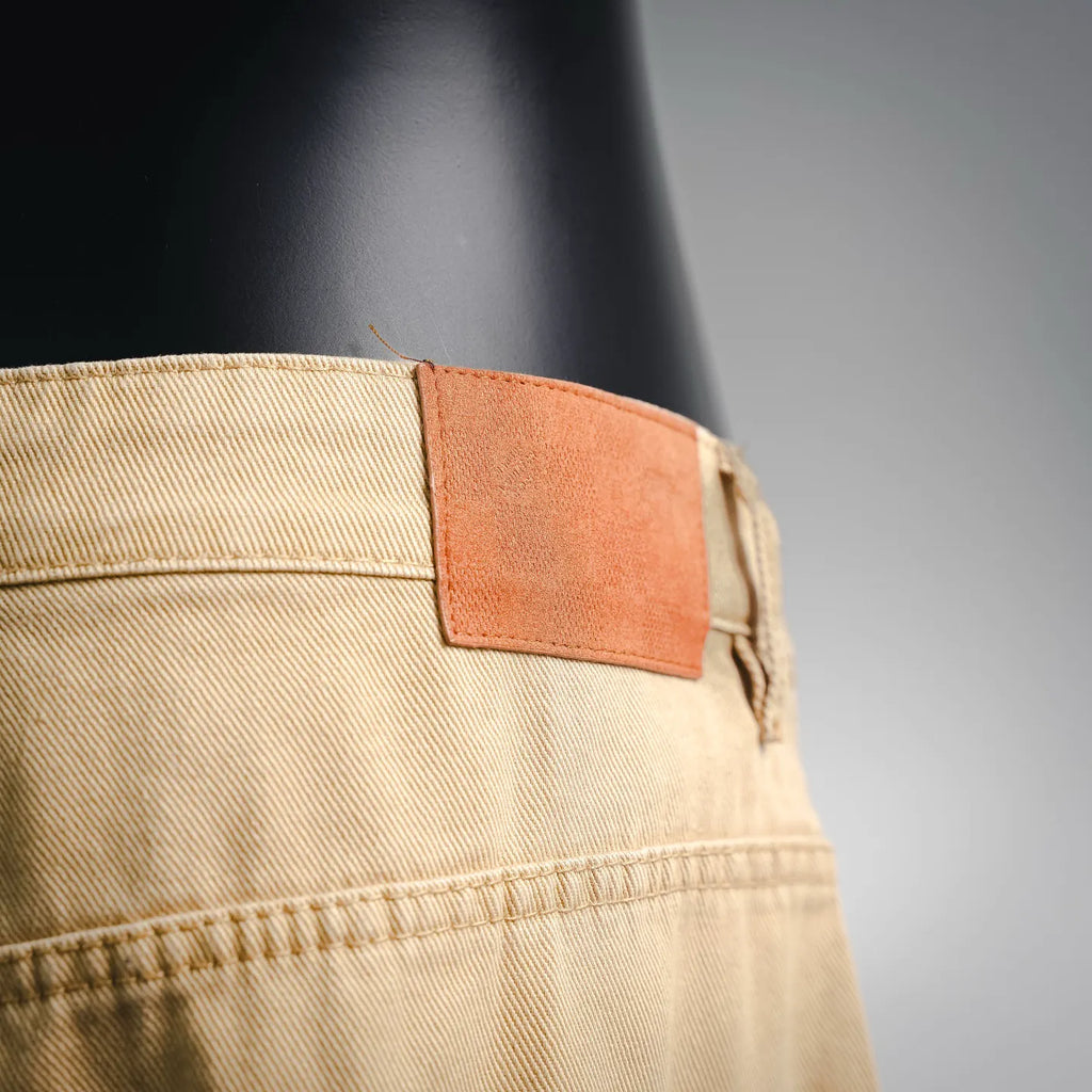 Beige LV shorts waistband close-up with orange fabric label patch