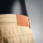 Beige LV shorts waistband close-up with orange fabric label patch
