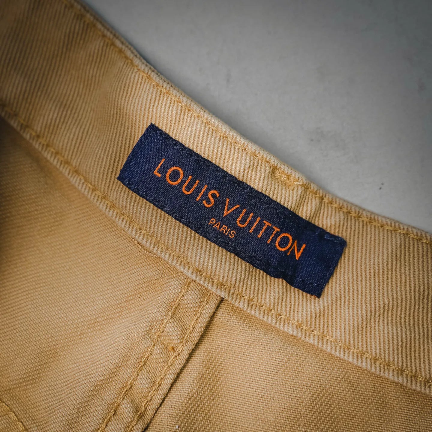 Beige LV shorts inner label with "LOUIS VUITTON" text