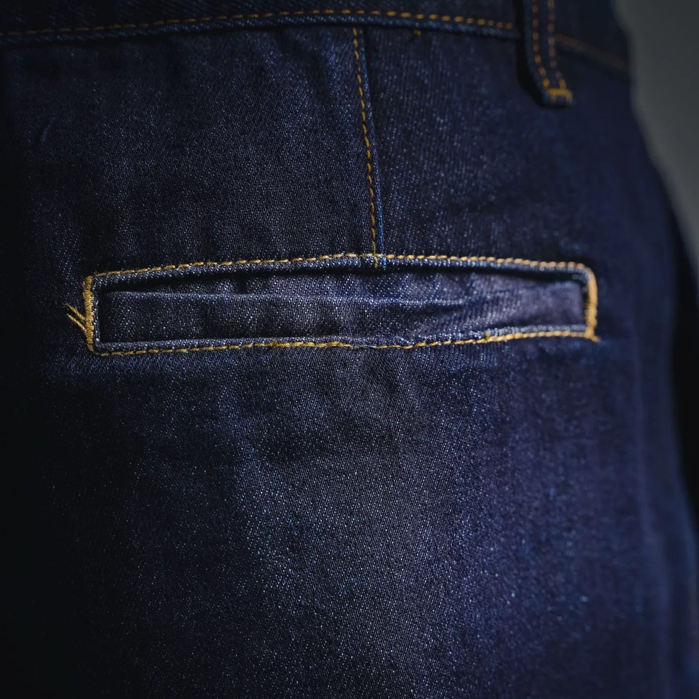 LV dark blue denim shorts front pocket close-up with yellow topstitching