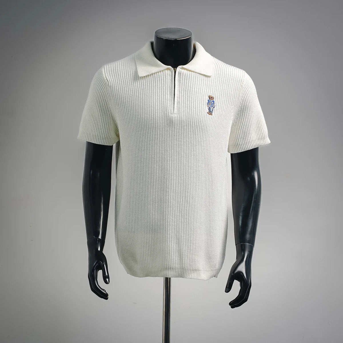 Off-white knit short-sleeve polo with buttonless half-zip and embroidered bear logo