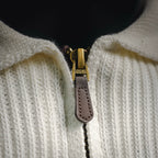 Half-zip with brown leather pull tab on off-white knit polo