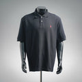 Dark navy polo shirt with button placket and small pink embroidered logo on chest