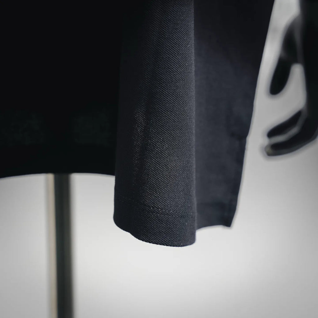 Dark navy polo shirt sleeve close-up showing textured fabric knit
