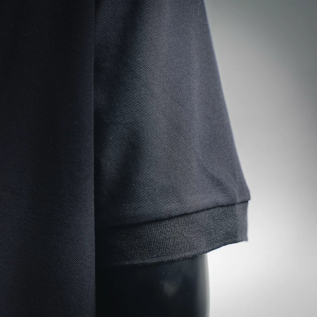 Dark navy polo shirt hem and sleeve cuff close-up with ribbed trim