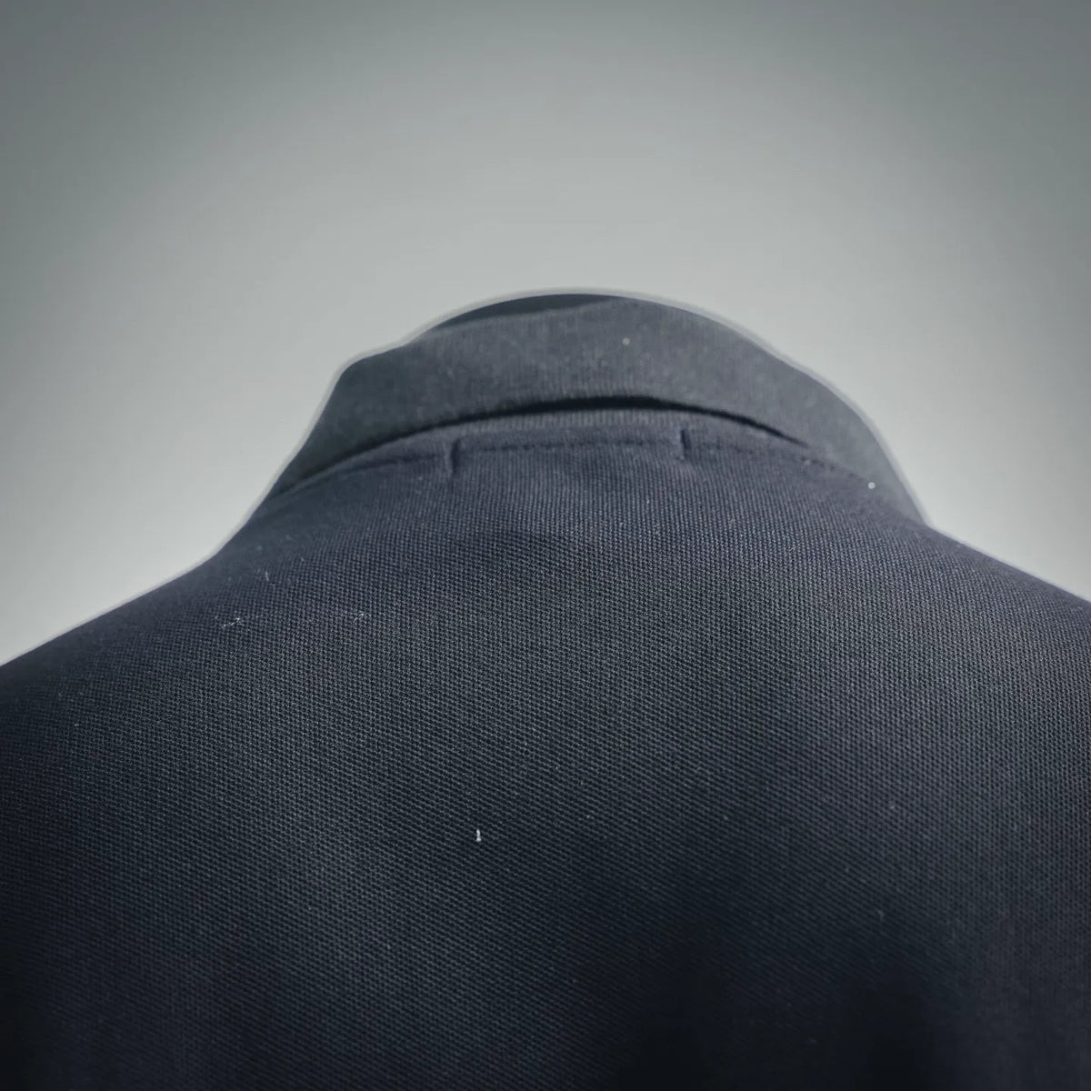 Dark navy polo shirt shoulder and collar seam close-up with ribbed neckline