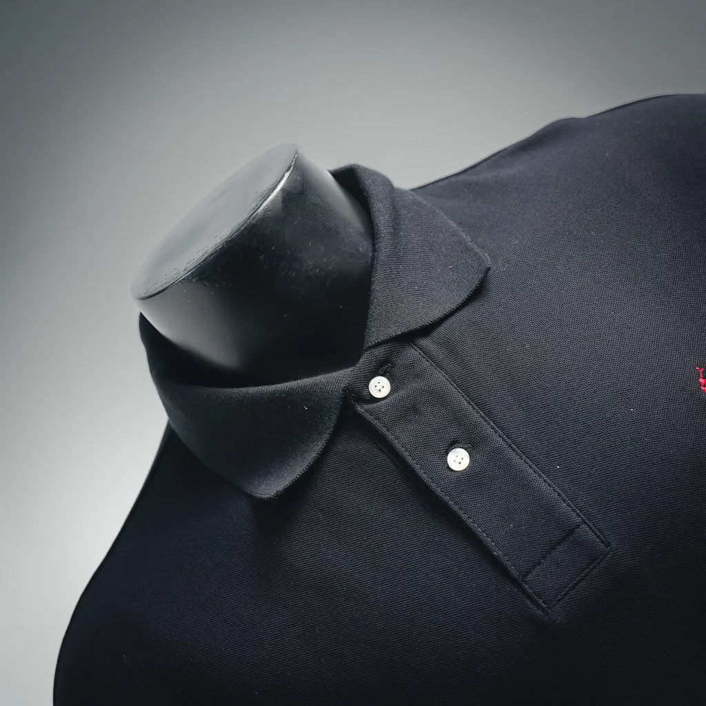 Dark navy polo shirt neckline close-up with button placket and chest pocket seam