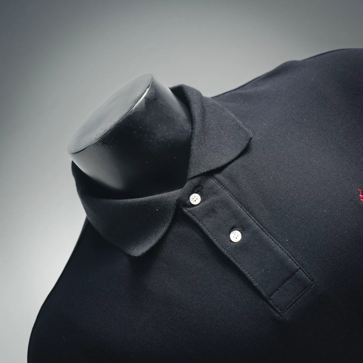 Dark navy polo shirt neckline close-up with button placket and chest pocket seam