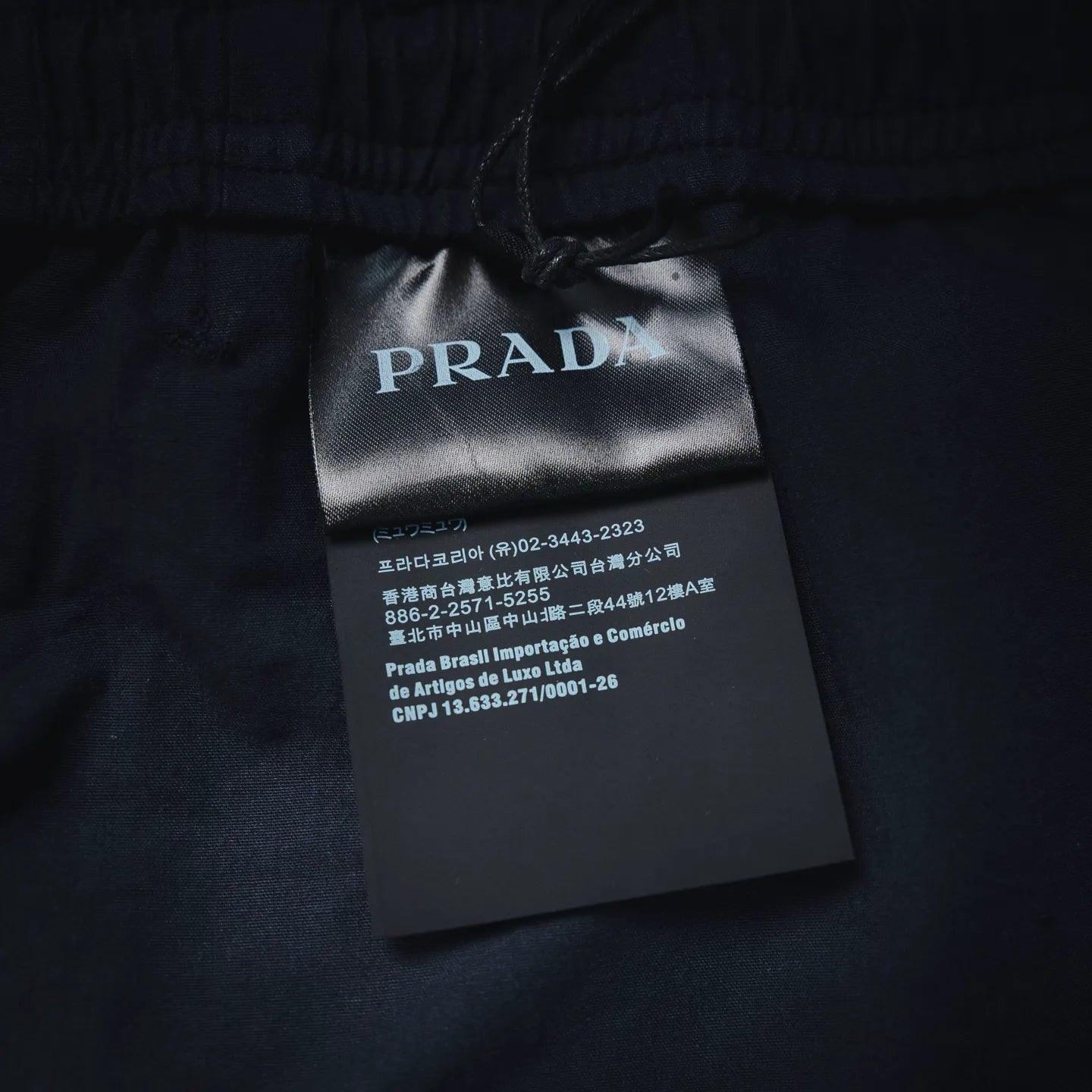 Prada fabric care tag on navy pants waistband