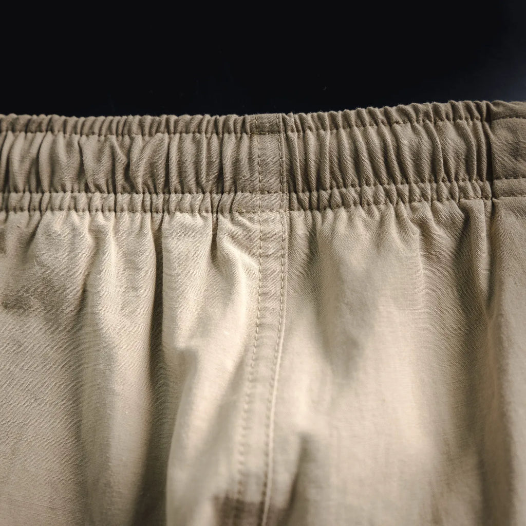 Beige pants waistband with gathered elastic and stitched seam detail