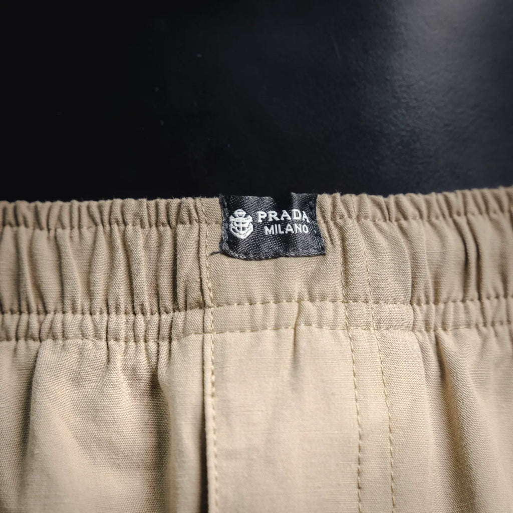 Beige pants with Prada Milano logo patch on elastic waistband