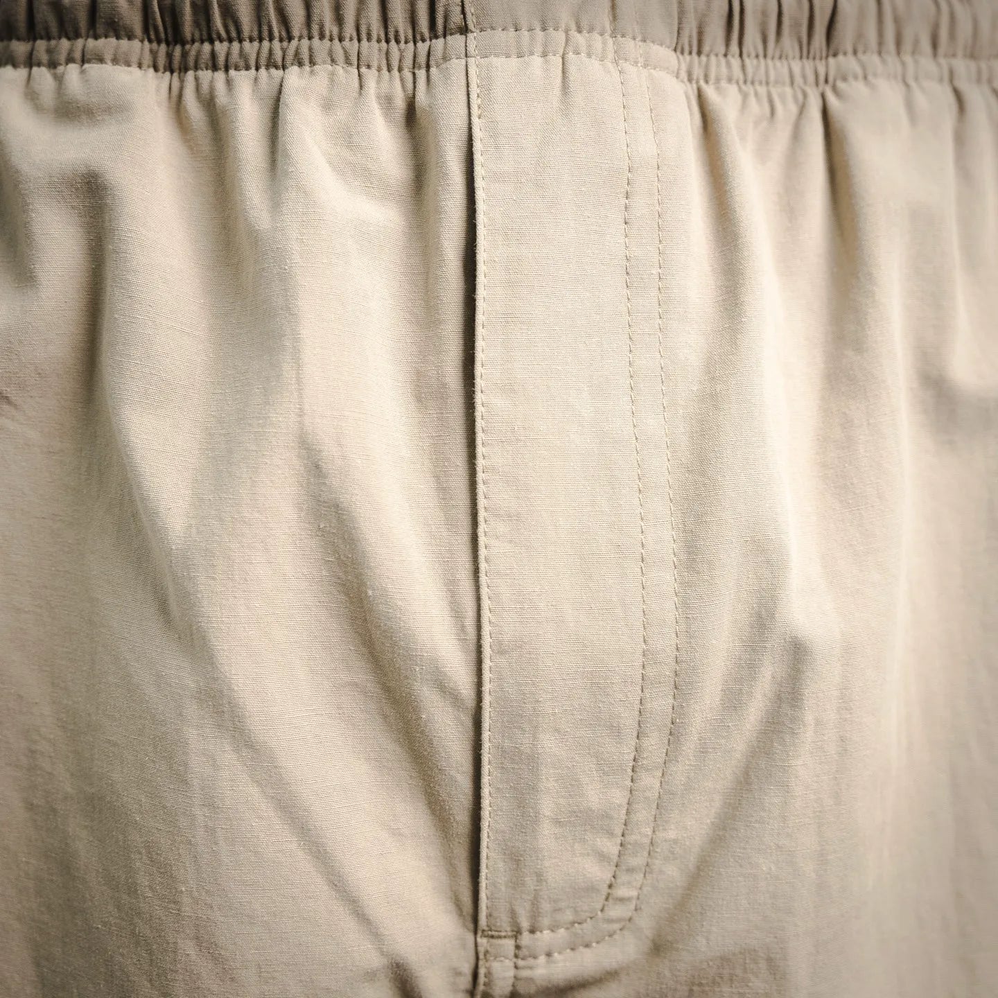 Beige pants inner fly seam and waistband stitching detail