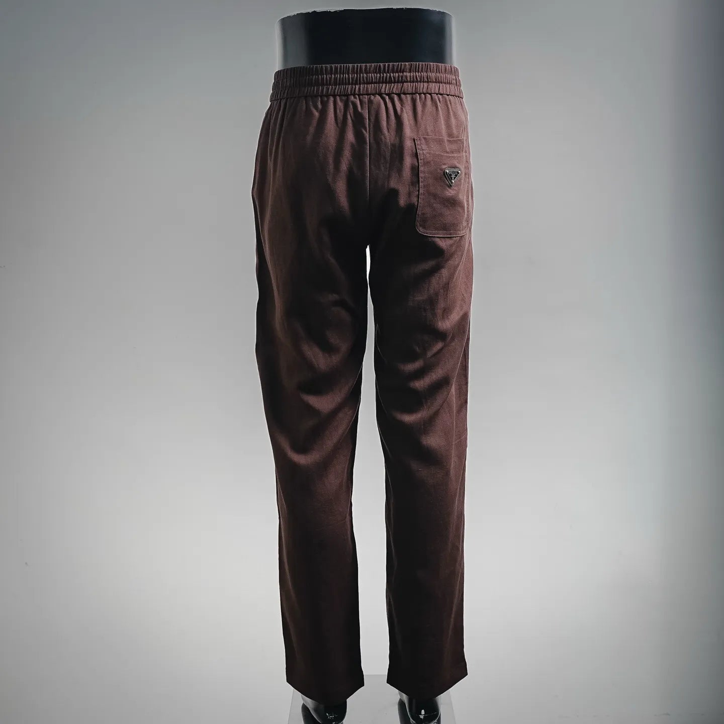 Prada pants in dark burgundy with elastic waistband, side pocket detail, tapered fit