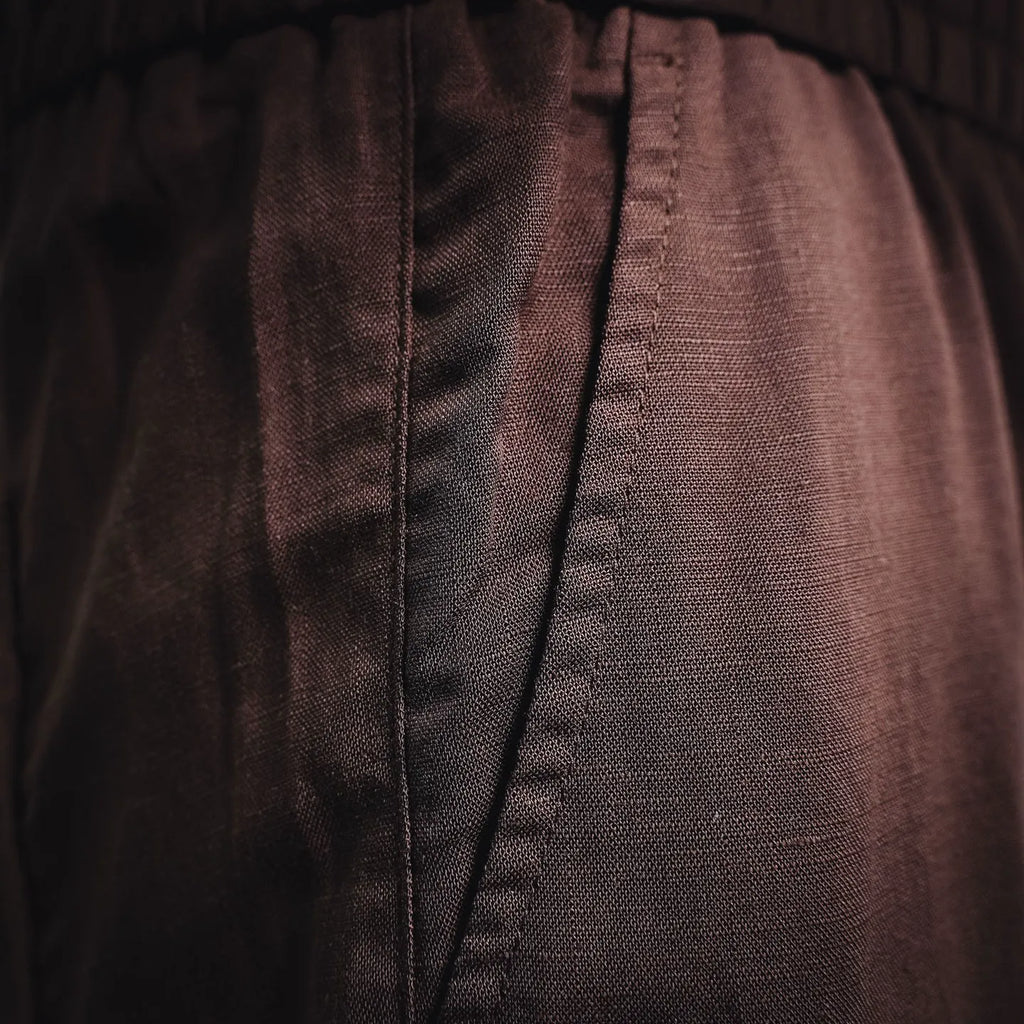 Prada pants seam and textured fabric close-up in dark burgundy