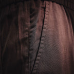 Prada pants seam and textured fabric close-up in dark burgundy