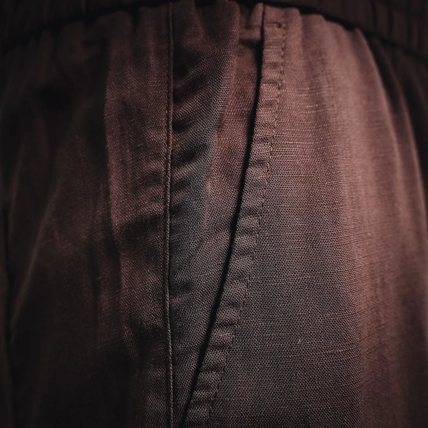 Prada pants seam and textured fabric close-up in dark burgundy