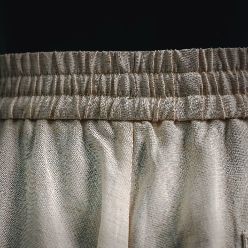 Light beige pants with elastic waistband and gathered seam detail