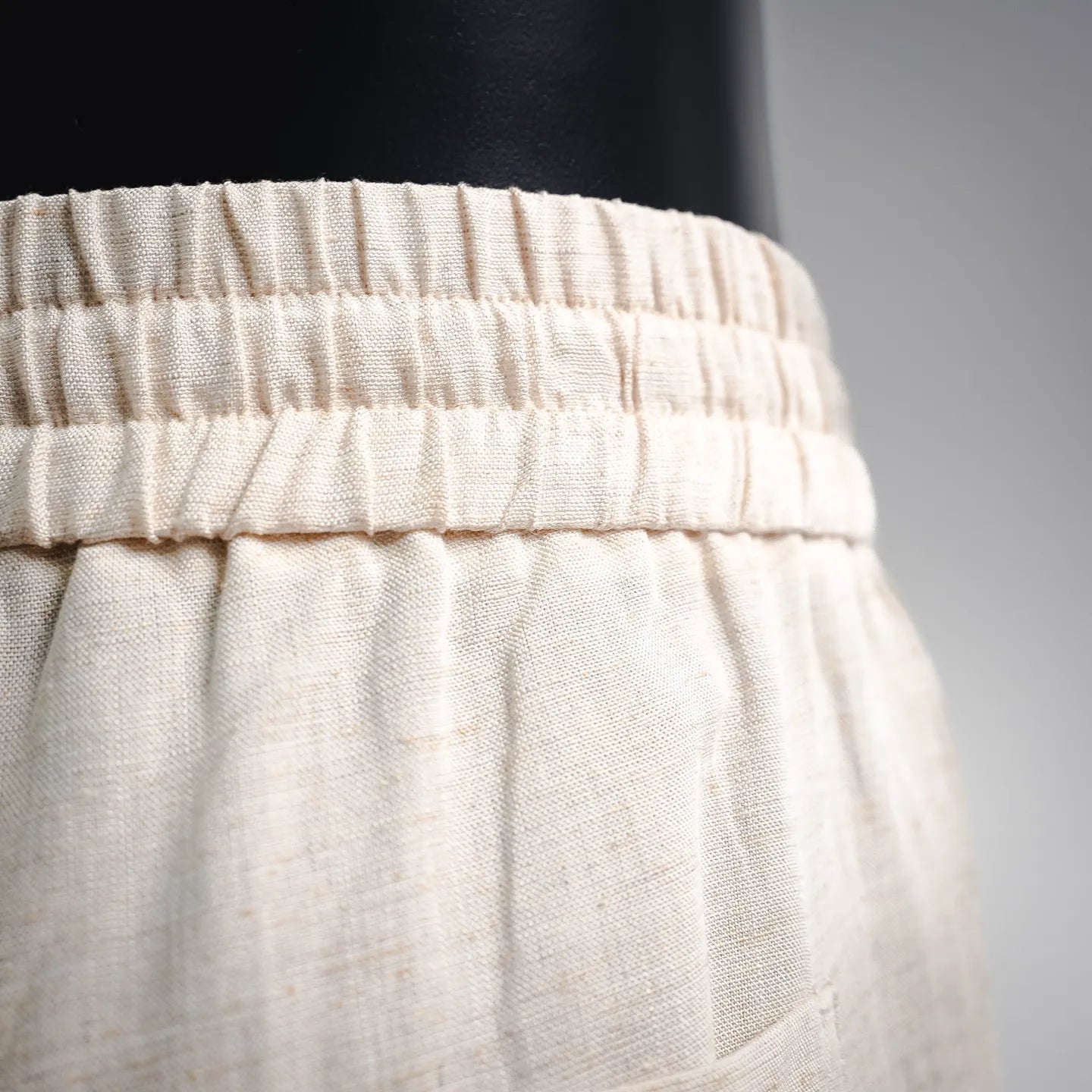 Light beige pants with elastic waistband and stitched waistband seam