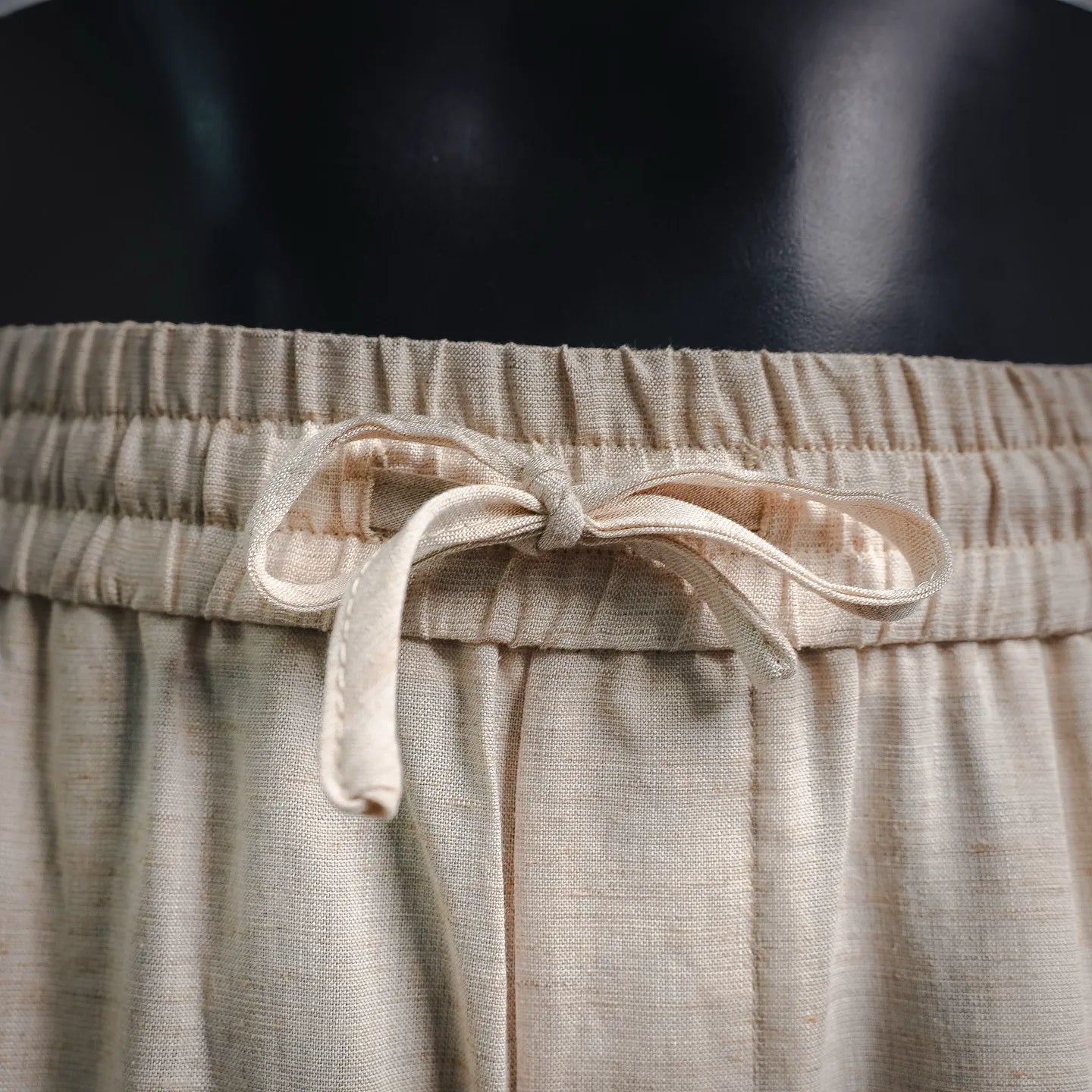 Light beige pants with tied drawstring at elastic waist