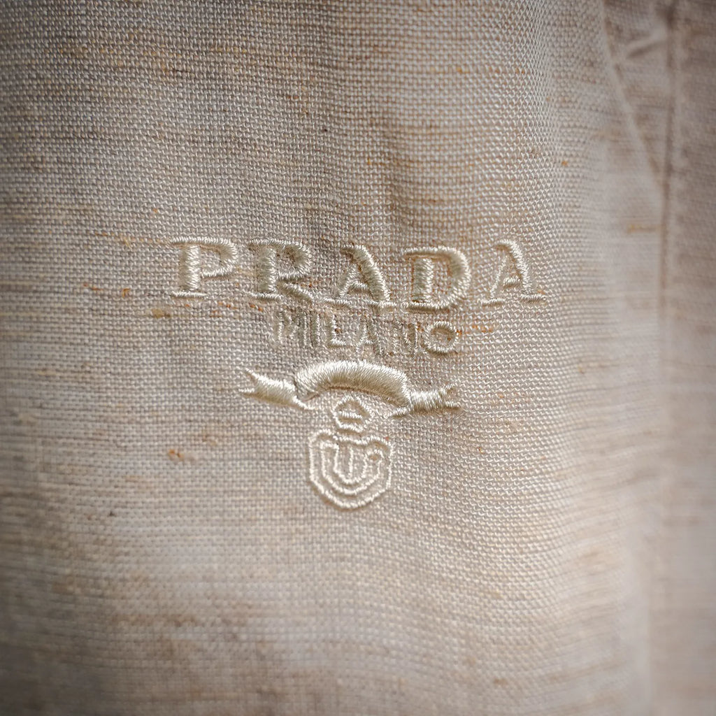 Light beige pants with embroidered PRADA MILANO logo on front