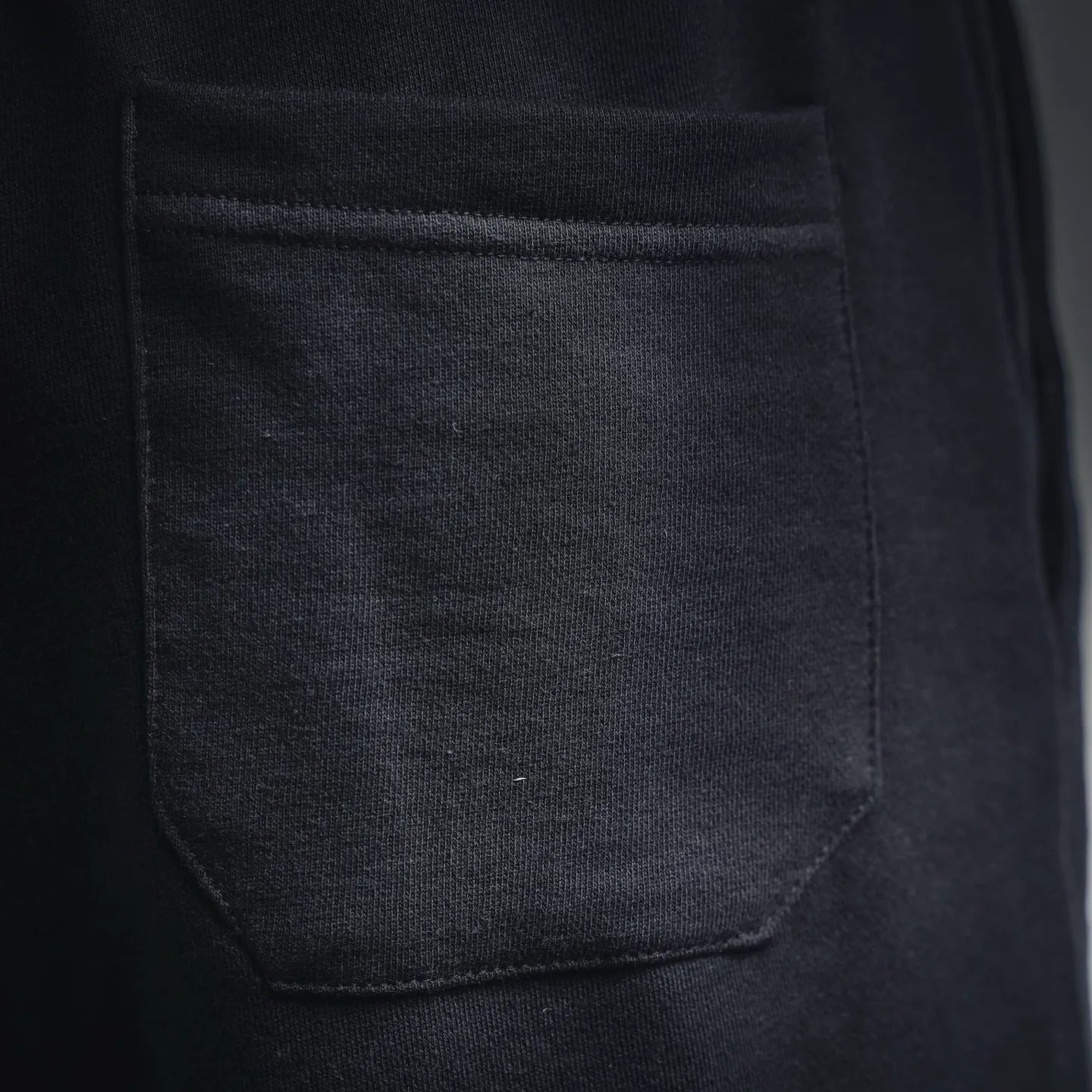 Dark gray front pocket with stitched seam on track shorts