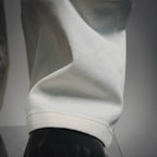 White pants hem and cuff detail with a visible stitched seam.
