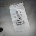 Care label inside white Prada pants with washing and handling symbols.