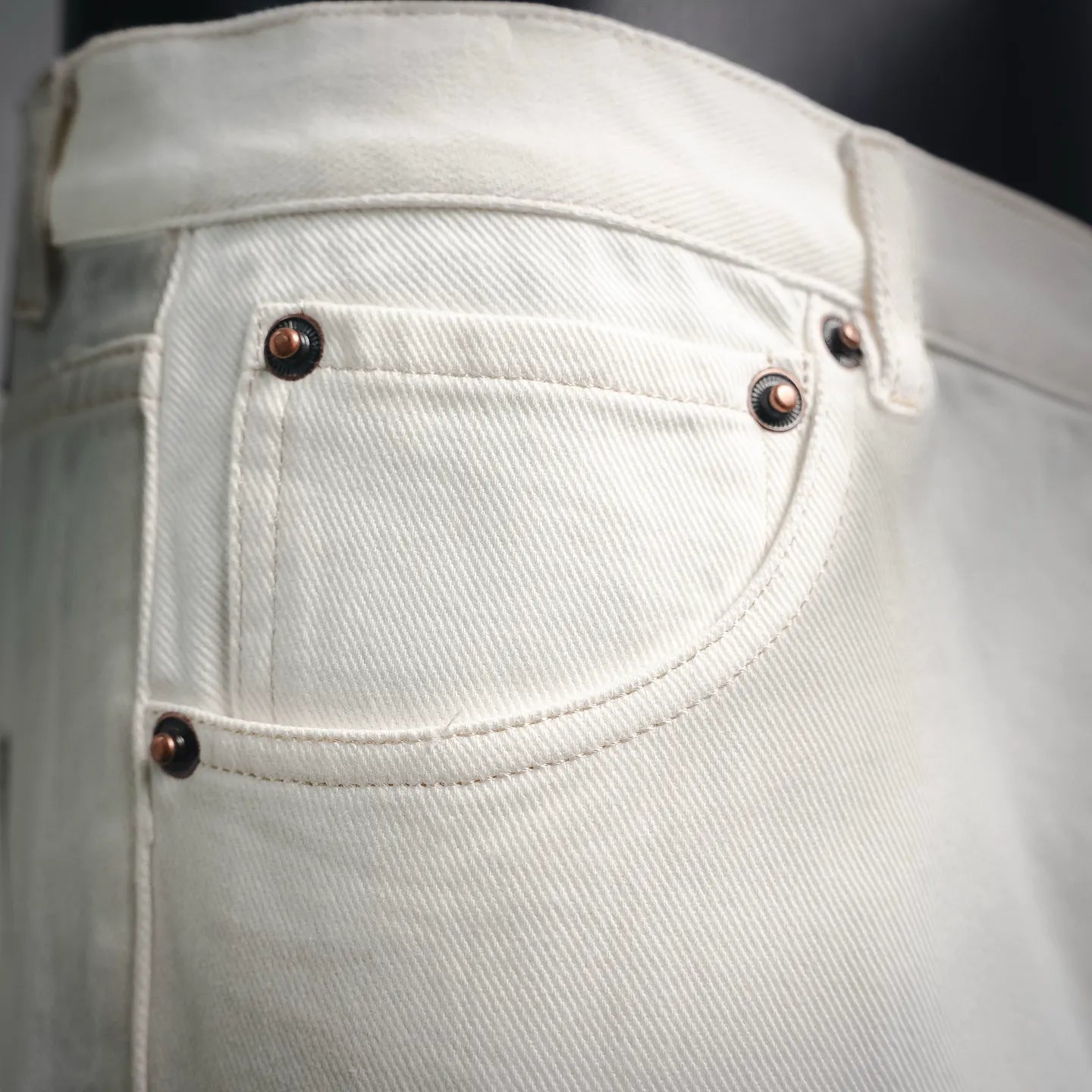 White Prada pants front pocket with dark buttons and rivets.