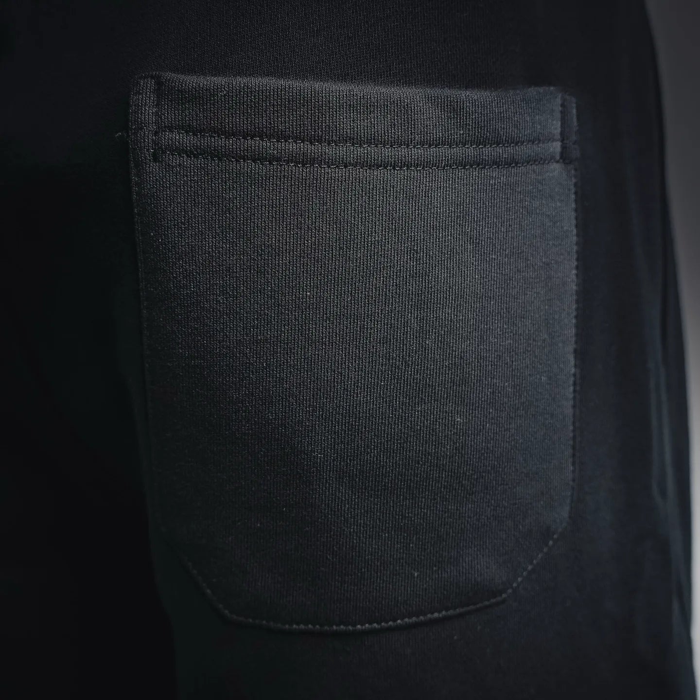 Black side pocket with stitched edge on knee-length shorts