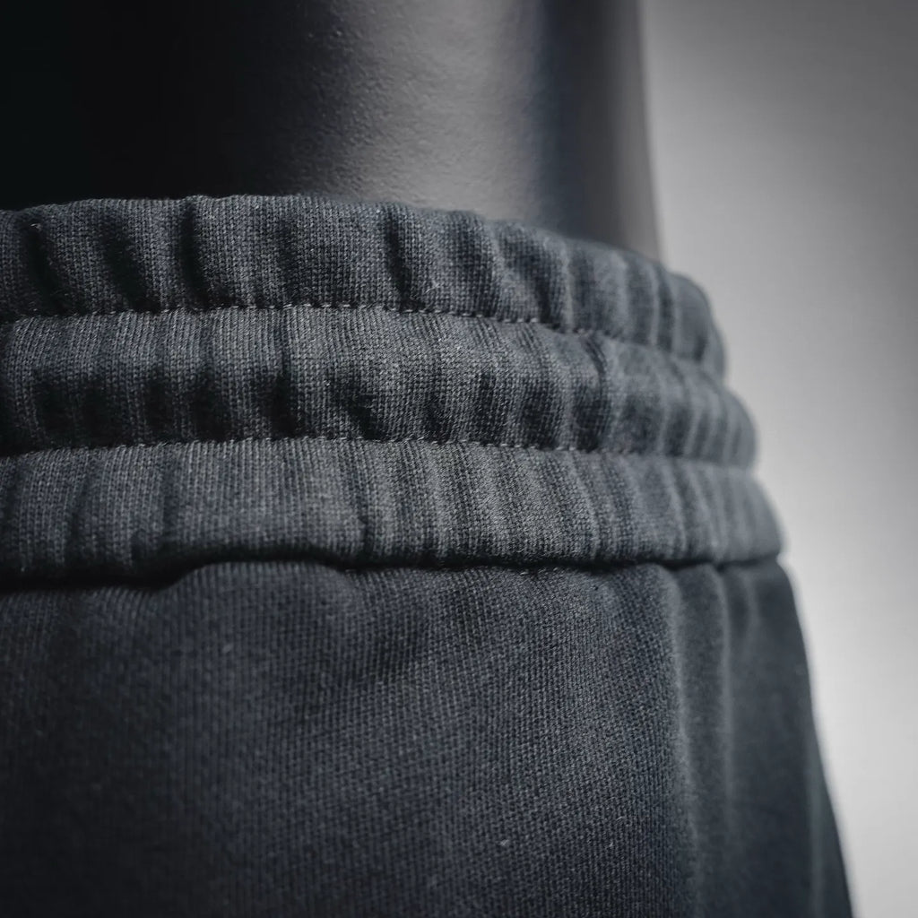 Ruffled elastic waistband on black shorts, close-up detail