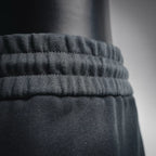 Ruffled elastic waistband on black shorts, close-up detail