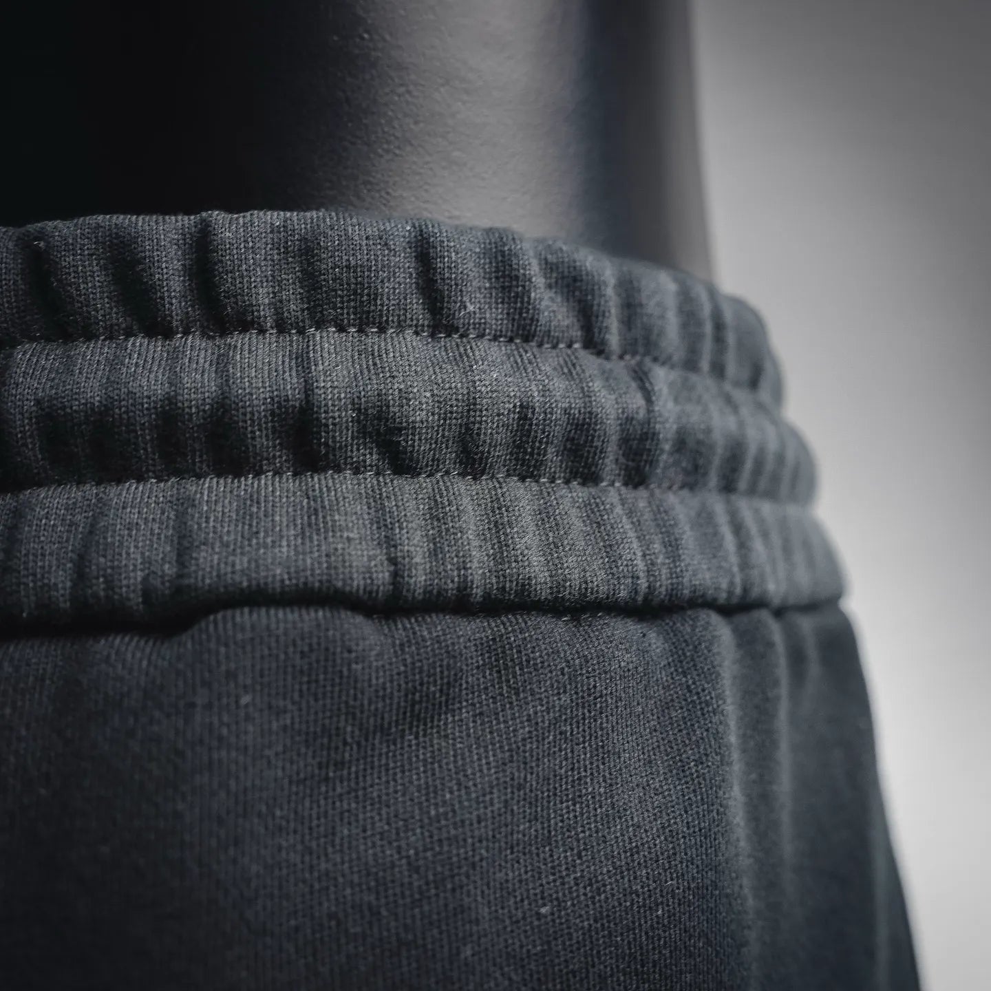 Ruffled elastic waistband on black shorts, close-up detail