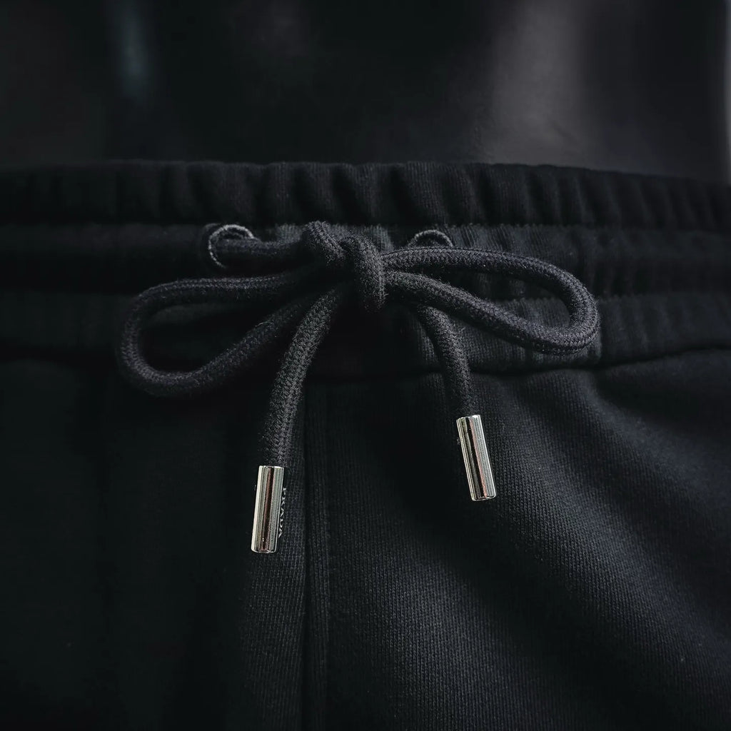 Black shorts with elastic waistband and metal-tipped drawstrings