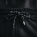 Black shorts with elastic waistband and metal-tipped drawstrings