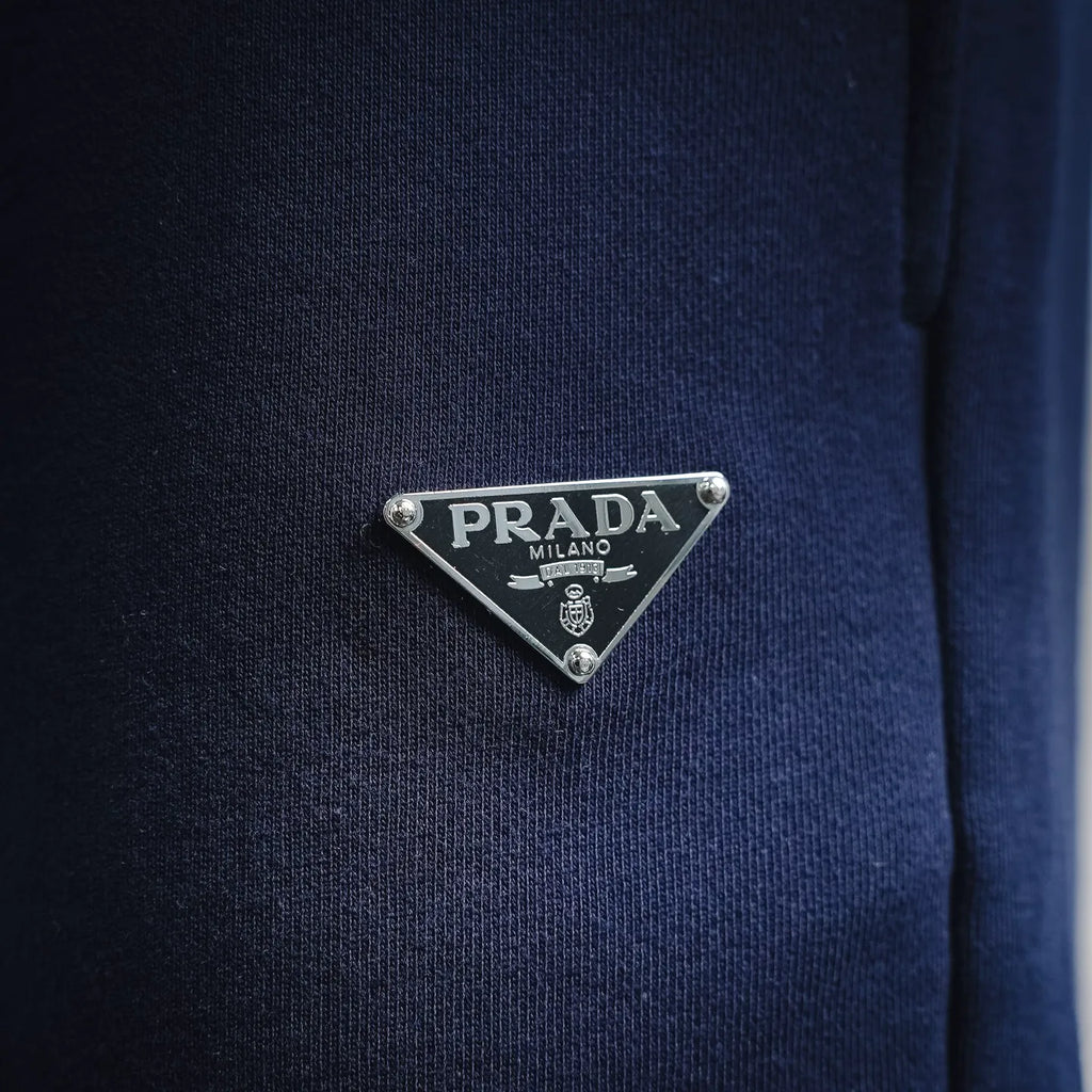 Prada logo triangle metal patch on blue shorts