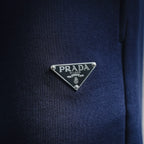 Prada logo triangle metal patch on blue shorts