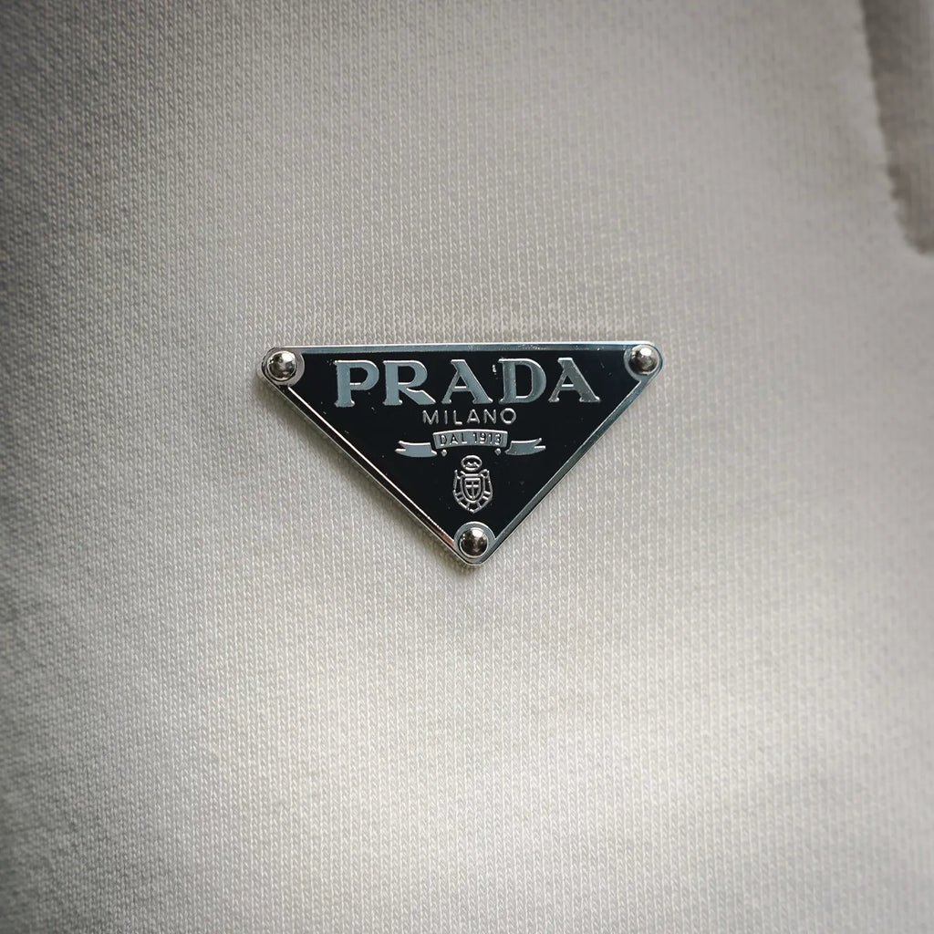 Prada Milano triangular logo patch on white fabric