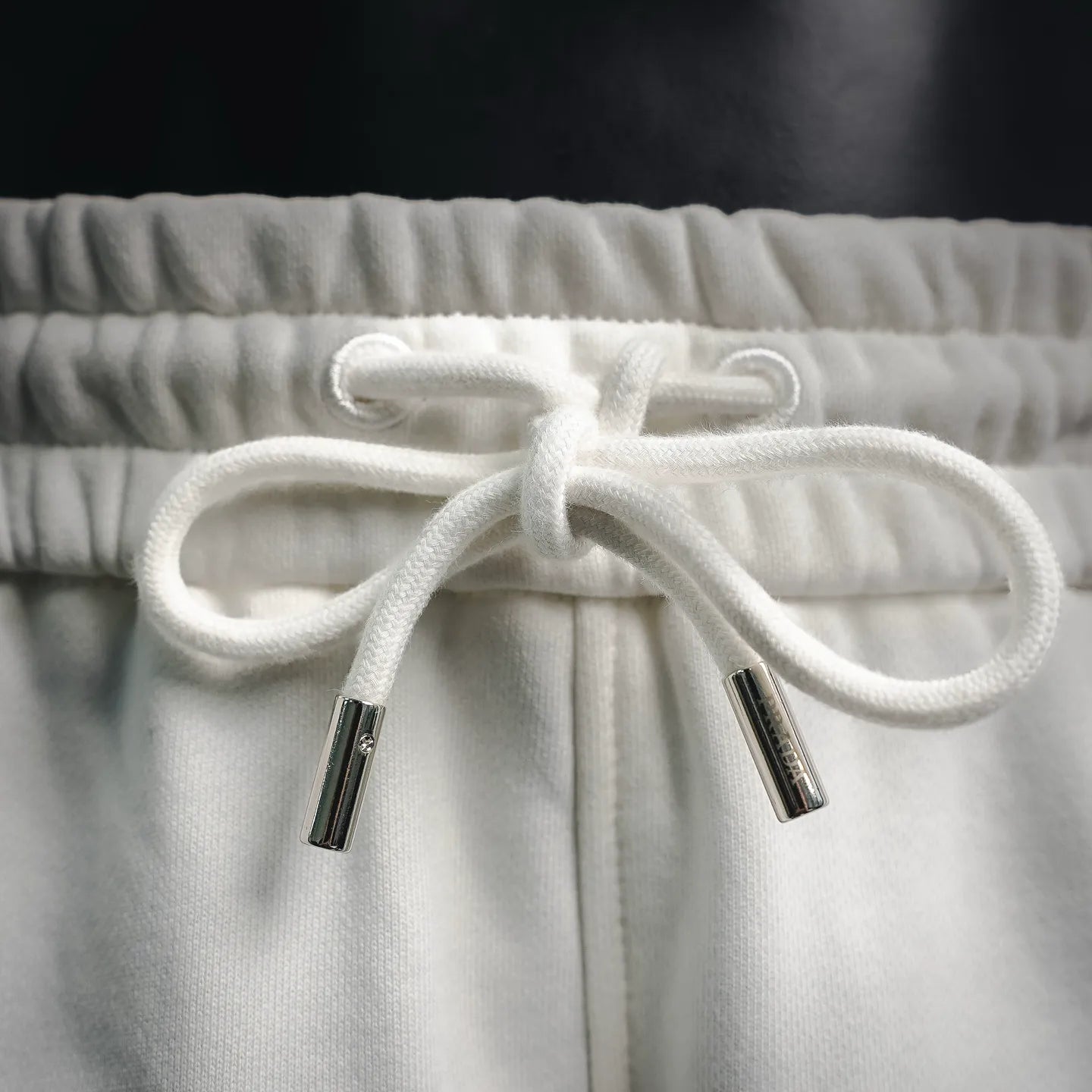 White drawstring with two cord aglets on elastic waistband