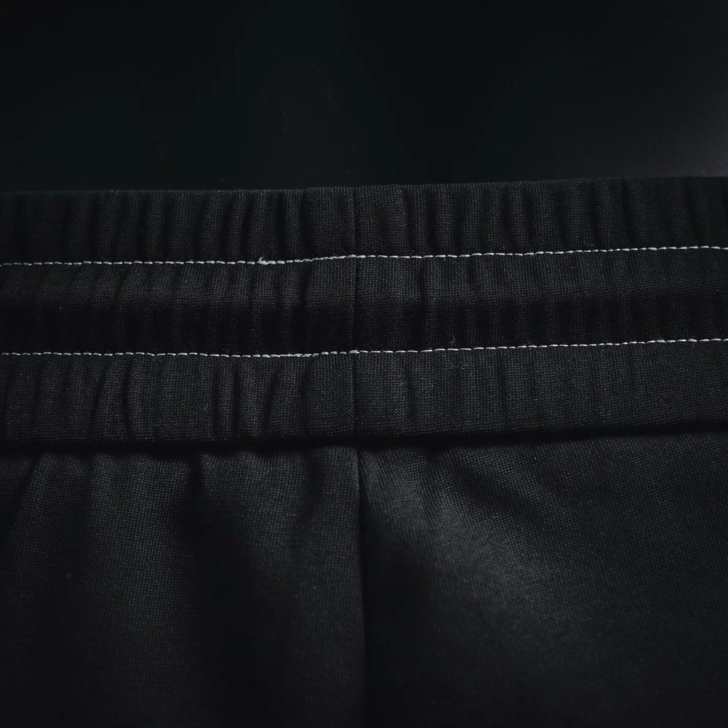 Prada black pants waistband close-up with stitched elastic detail